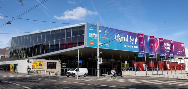 A woman walks past the Stadthalle, the venue of the Eurovision Song Contest (ESC), as preparations are underway in Vienna during a media tour on April 9, 2026. The Austrian capital Vienna will host the Eurovision Song Contest 2026 from May 12 to 16, 2026. (Photo by Joe Klamar / APA / AFP) / Austria OUT