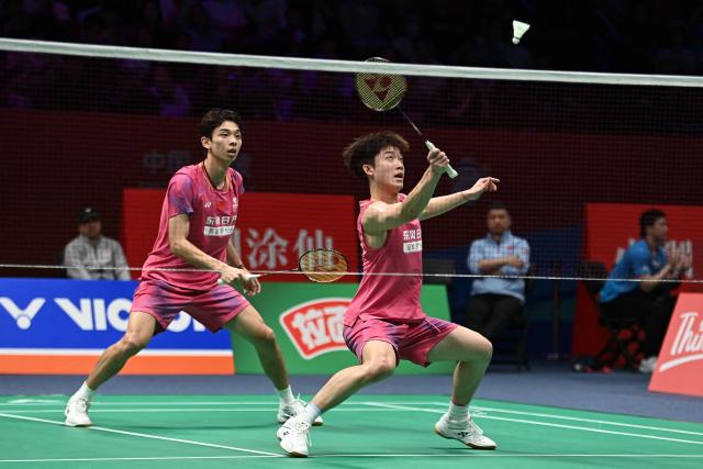 Hu Keyuan (R) and Lin Xiangyi (L) of China hit a return to Aaron Chia and Soh Wooi Yik of Malaysia during their men's doubles match at the Badminton Asia Championship in Ningbo, eastern China's Zhejiang province on April 9, 2026. (Photo by CN-STR / AFP) / China OUT