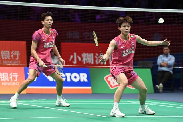 Hu Keyuan (R) and Lin Xiangyi (L) of China hit a return to Aaron Chia and Soh Wooi Yik of Malaysia during their men's doubles match at the Badminton Asia Championship in Ningbo, eastern China's Zhejiang province on April 9, 2026. (Photo by CN-STR / AFP) / China OUT