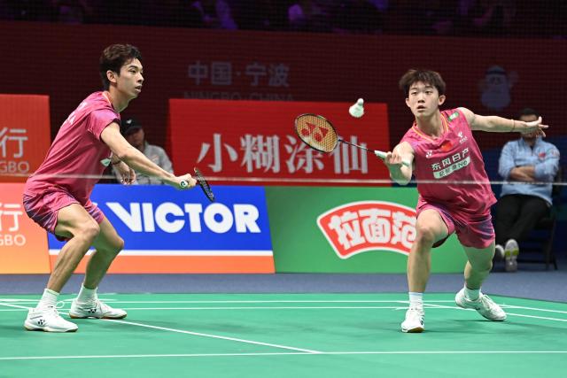 Hu Keyuan (R) and Lin Xiangyi (L) of China hit a return to Aaron Chia and Soh Wooi Yik of Malaysia during their men's doubles match at the Badminton Asia Championship in Ningbo, eastern China's Zhejiang province on April 9, 2026. (Photo by CN-STR / AFP) / China OUT