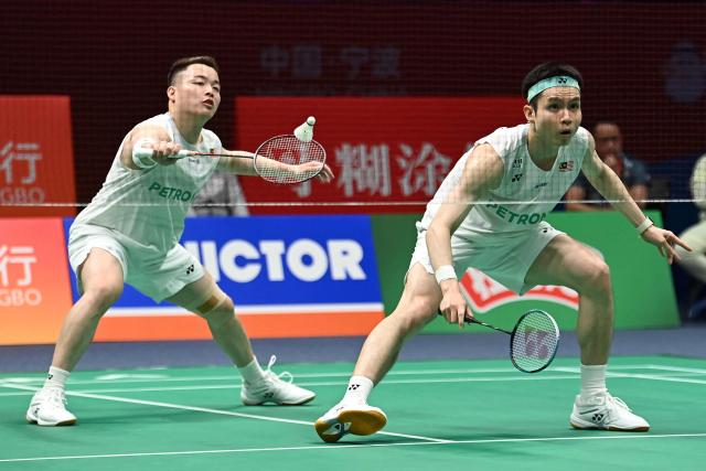 Soh Wooi Yik (L) and Aaron Chia (R) of Malaysia hit a return to Hu Keyuan and Lin Xiangyi of China during their men's doubles match at the Badminton Asia Championship in Ningbo, eastern China's Zhejiang province on April 9, 2026. (Photo by CN-STR / AFP) / China OUT