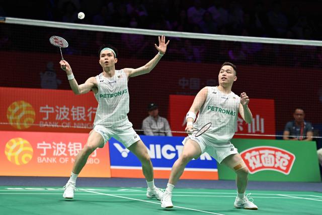 Soh Wooi Yik (L) and Aaron Chia (R) of Malaysia hit a return to Hu Keyuan and Lin Xiangyi of China during their men's doubles match at the Badminton Asia Championship in Ningbo, eastern China's Zhejiang province on April 9, 2026. (Photo by CN-STR / AFP) / China OUT