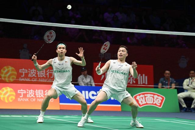 Soh Wooi Yik (L) and Aaron Chia (R) of Malaysia hit a return to Hu Keyuan and Lin Xiangyi of China during their men's doubles match at the Badminton Asia Championship in Ningbo, eastern China's Zhejiang province on April 9, 2026. (Photo by CN-STR / AFP) / China OUT