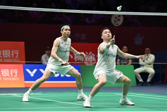 Soh Wooi Yik (L) and Aaron Chia (R) of Malaysia hit a return to Hu Keyuan and Lin Xiangyi of China during their men's doubles match at the Badminton Asia Championship in Ningbo, eastern China's Zhejiang province on April 9, 2026. (Photo by CN-STR / AFP) / China OUT