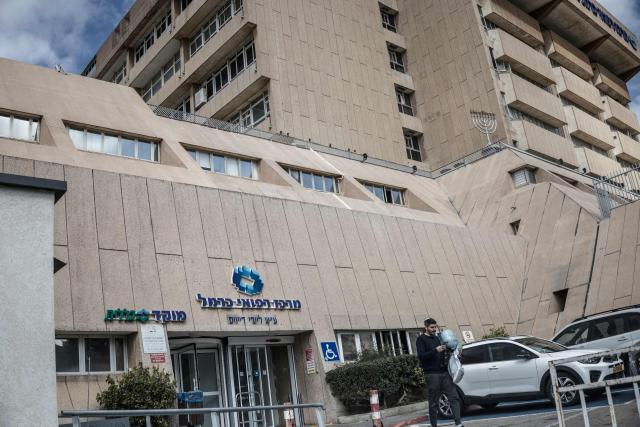 A man walks past the entrance to the Carmel Medical Center in the northern Israeli city of Haifa, on April 9, 2026. The hospital, built in the tip of the one of the mountains of the Carmel Mountain Range is part of the Clalit Health Services, the largest health organisation in Israel running 14 hospitals across the country. At least 14 rocket alerts sounded through April 9 morning in communities near Israel's northern border with Lebanon as Israeli forces fight Hezbollah despite the US-Iran ceasefire. (Photo by MARCO LONGARI / AFP)
