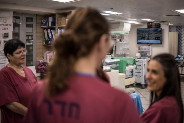 A television channel transmits images of missiles being prepared to be launched in Iran as midwives gather in the neonatal unit in the underground bomb shelter built into the Carmel Medical Center in the northern Israeli city of Haifa, on April 9, 2026. The hospital, built in the tip of the one of the mountains of the Carmel Mountain Range is part of the Clalit Health Services, the largest health organisation in Israel running 14 hospitals across the country. At least 14 rocket alerts sounded through April 9 morning in communities near Israel's northern border with Lebanon as Israeli forces fight Hezbollah despite the US-Iran ceasefire. (Photo by MARCO LONGARI / AFP)