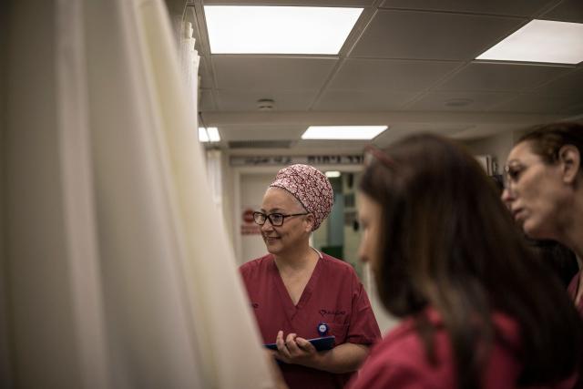 Miri Yahalom (C), Chief Midwife of the delivery room visits a patient in labor in the underground bomb shelter built into the Carmel Medical Center in the northern city of Haifa, on April 9, 2026. The hospital, built in the tip of the one of the mountains of the Carmel Mountain Range is part of the Clalit Health Services, the largest health organisation in Israel running 14 hospitals across the country. At least 14 rocket alerts sounded through April 9 morning in communities near Israel's northern border with Lebanon as Israeli forces fight Hezbollah despite the US-Iran ceasefire. (Photo by MARCO LONGARI / AFP)