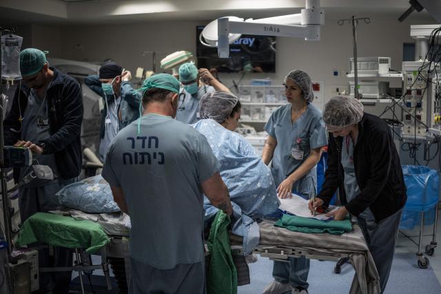 Israeli woman Sarah Bird is prepared for the delivery of her third baby at the operating theatre of the neonatal unit in the underground bomb shelter built into the Carmel Medical Center in the northern city of Haifa, on April 9, 2026. The hospital, built in the tip of the one of the mountains of the Carmel Mountain Range is part of the Clalit Health Services, the largest health organisation in Israel running 14 hospitals across the country. At least 14 rocket alerts sounded through April 9 morning in communities near Israel's northern border with Lebanon as Israeli forces fight Hezbollah despite the US-Iran ceasefire. (Photo by MARCO LONGARI / AFP)