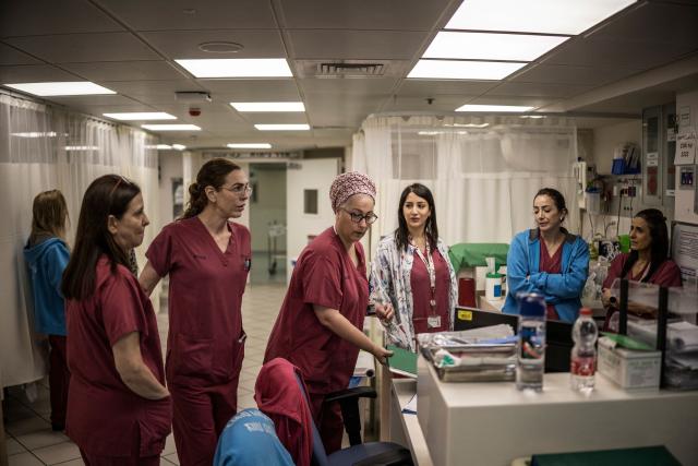 Miri Yahalom (C), Chief Midwife of the delivery room performs the morning rounds in the underground bomb shelter built into the Carmel Medical Center in the northern Israeli city of Haifa, on April 9, 2026. The hospital, built in the tip of the one of the mountains of the Carmel Mountain Range is part of the Clalit Health Services, the largest health organisation in Israel running 14 hospitals across the country. At least 14 rocket alerts sounded through April 9 morning in communities near Israel's northern border with Lebanon as Israeli forces fight Hezbollah despite the US-Iran ceasefire. (Photo by MARCO LONGARI / AFP)