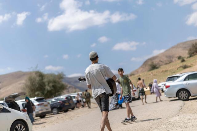 Israeli settlers gather at the Israeli-occupied West Bank village of Ras Ein al-Auja on April on April 9, 2026. Israel vowed more strikes against Hezbollah on April 9, dismissing mounting international demands that the fragile truce between the United States and Iran in the Gulf be expanded to cover the war in Lebanon. (Photo by Ilia YEFIMOVICH / AFP)