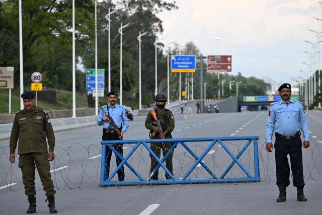 Security personnel stand guard on a closed road near Red Zone area in Islamabad on April 9, 2026. Pakistan has been preparing for high-stakes talks involving US and Iranian representatives over the war in the Middle East, with the White House saying Vice President JD Vance will be leading a team to the negotiations in Islamabad "this weekend". (Photo by Aamir QURESHI / AFP)