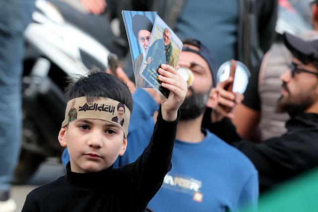 A youbg bo holds photos of Iran's slain Supreme Leader Ayatollah Ali Khamenei (back) and slain Hezbollah Commander Ali Karaki during an anti-government protest outside the Lebanese governmental palace in Beirut on April 9, 2026. Lebanon's cabinet on April 9 instructed security forces to restrict weapons in Beirut exclusively to state institutions, in a warning to Hezbollah a day after Israel launched strikes across the country including the capital. (Photo by ibrahim AMRO / AFP)