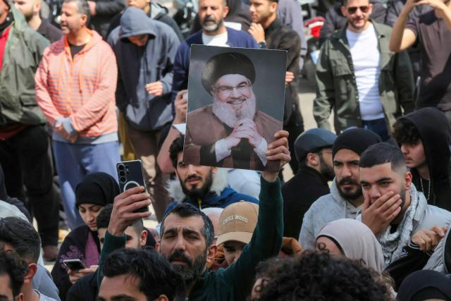 A Hezbollah supporter holds a portrait of slain Hezbollah leader Hassan Nasrallah during an anti-government protest outside the Lebanese governmental palace in Beirut on April 9, 2026. Lebanon's cabinet on April 9 instructed security forces to restrict weapons in Beirut exclusively to state institutions, in a warning to Hezbollah a day after Israel launched strikes across the country including the capital. (Photo by ibrahim AMRO / AFP)