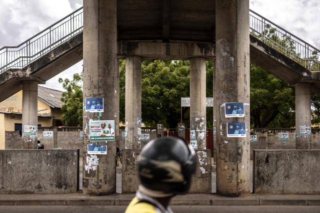 A motorist rides past election posters in Cotonou, on April 9, 2026, ahead of Benin's presidential election scheduled for April 12, 2026. (Photo by OLYMPIA DE MAISMONT / AFP)