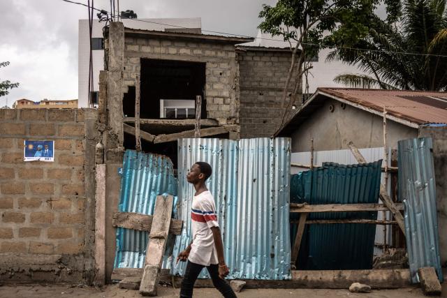 A resident walks pant an election poster of Romuald Wadagni, presidential candidate and Minister of Finance in Cotonou, on April 9, 2026, ahead of Benin's presidential election scheduled for April 12, 2026. (Photo by OLYMPIA DE MAISMONT / AFP)