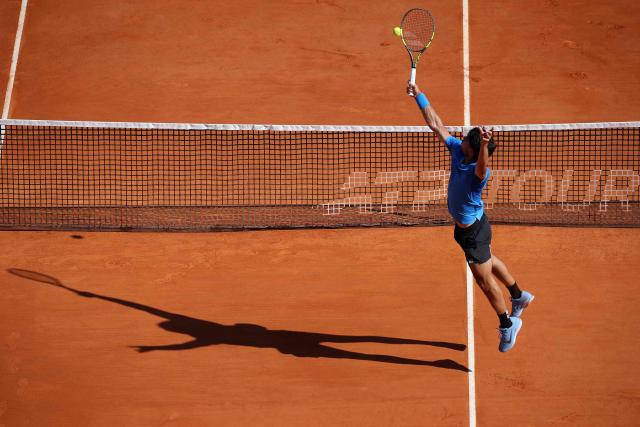 Spain's Carlos Alcaraz stretches to return to Argentina's Tomas Martin Etcheverry during their Monte Carlo ATP Masters Series Tournament round of 16 tennis match on Court Rainier III at the Monte-Carlo Country Club in Roquebrune-Cap-Martin, south-eastern France on April 9, 2026. (Photo by Valery HACHE / AFP)