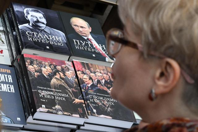 A woman looks at books about Russian leaders of different times at the Non/Fiction book fair in Moscow on April 9, 2026. (Photo by Igor IVANKO / AFP)
