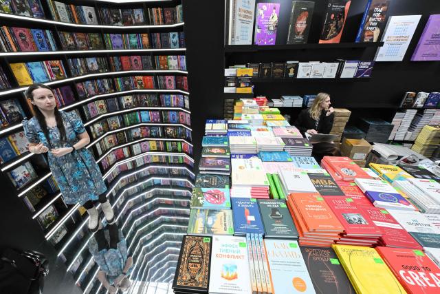 A woman stands in front of bookshelves at the Non/Fiction book fair in Moscow on April 9, 2026. (Photo by Igor IVANKO / AFP)