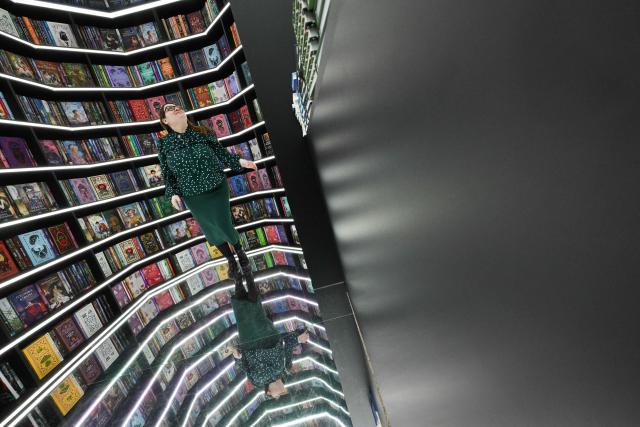 A woman poses in front of bookshelves at the Non/Fiction book fair in Moscow on April 9, 2026. (Photo by Igor IVANKO / AFP)