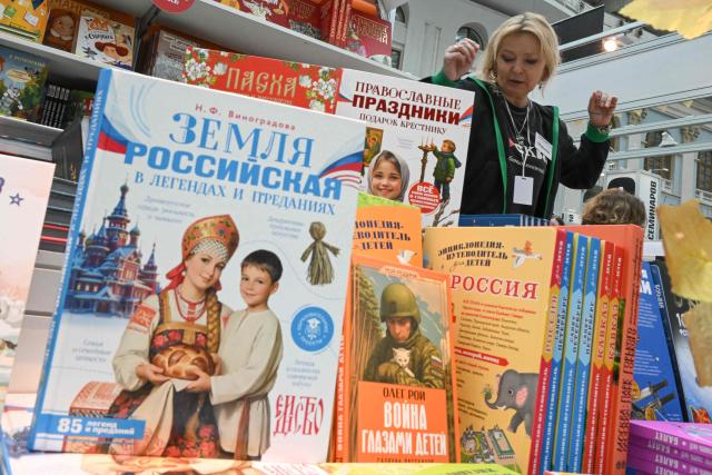 A woman sells books about Russian culture, history and traditions for children at the Non/Fiction book fair in Moscow on April 9, 2026. (Photo by Igor IVANKO / AFP)