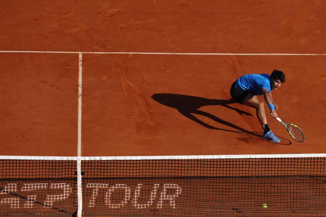 Spain's Carlos Alcaraz stretches to return to Argentina's Tomas Martin Etcheverry during their Monte Carlo ATP Masters Series Tournament round of 16 tennis match on Court Rainier III at the Monte-Carlo Country Club in Roquebrune-Cap-Martin, south-eastern France on April 9, 2026. (Photo by Valery HACHE / AFP)