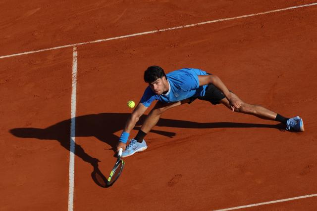 Spain's Carlos Alcaraz stretches to return to Argentina's Tomas Martin Etcheverry during their Monte Carlo ATP Masters Series Tournament round of 16 tennis match on Court Rainier III at the Monte-Carlo Country Club in Roquebrune-Cap-Martin, south-eastern France on April 9, 2026. (Photo by Valery HACHE / AFP)
