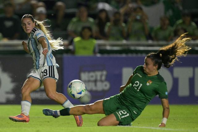 (FILES) Argentina's forward #19 Agostina Holzheier and Bolivia's midfielder #21 Abigail Quiroz fight for the ball during the Conmebol Women's Nations League 2025-26 football match between Argentina and Bolivia at the Florencio Sola Stadium in Banfield, Buenos Aires province on December 2, 2025. South American women's national football teams will set out to secure early qualification for the 2027 World Cup in Brazil, starting on April 10, 2026, a triple match day of the Nations League marked by fierce competition for the top spot. (Photo by JUAN MABROMATA / AFP)