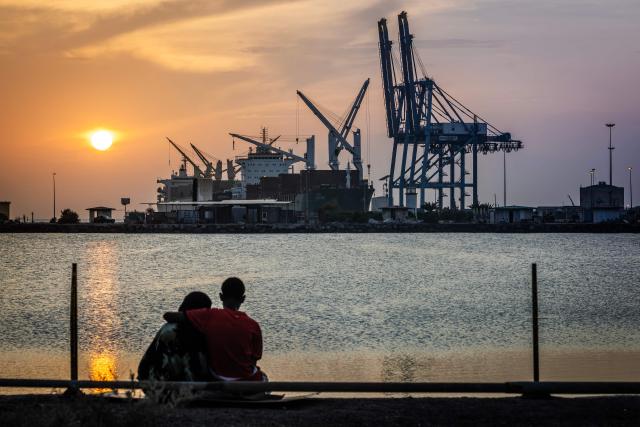 A couple observes the sunset as cargo ships are docked at a section of the port of Djibouti, the country’s main economic hub, in Djibouti, on April 9, 2026. (Photo by Luis TATO / AFP)