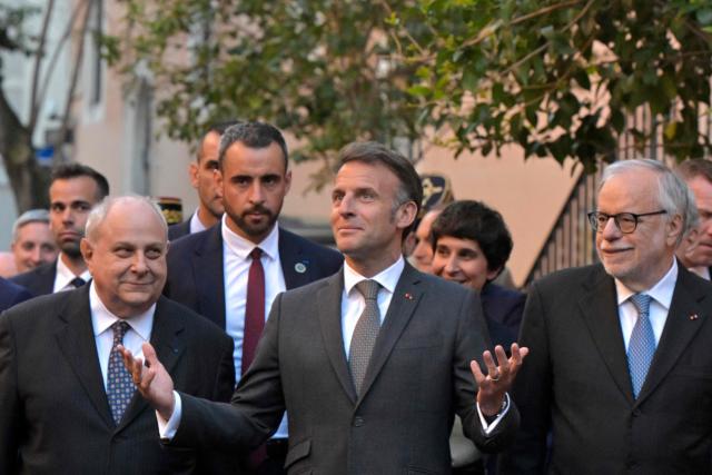 TOPSHOT - France's President Emmanuel Macron (C) walks in Trastevere neighborhood with the founder of the catholic charity Sant'Egidio community, Andrea Riccardi (R), in Rome on April 9, 2026. (Photo by Tiziana FABI / AFP)