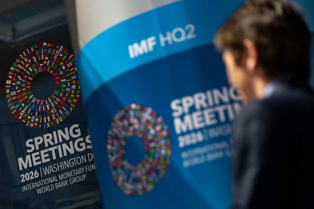 Signage for the upcoming International Monetary Fund (IMF) 2026 Spring Meetings are seen outside of the IMF headquarters in Washington, DC on April 9, 2026. The International Monetary Fund will lower global growth forecasts due to the Middle East war, its chief said April 9, warning of the conflict's "scarring effects" despite a fragile ceasefire. "Even in a best case, there will be no neat and clean return to the status quo ante," IMF managing director Kristalina Georgieva said. (Photo by Kent Nishimura / AFP)