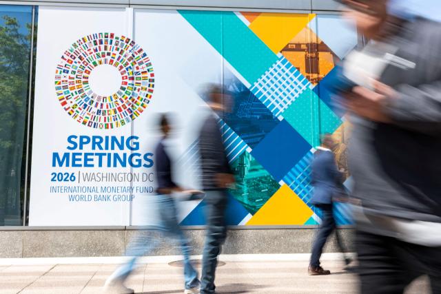 Signage for the upcoming International Monetary Fund (IMF) 2026 Spring Meetings are seen outside of the IMF headquarters in Washington, DC on April 9, 2026. The International Monetary Fund will lower global growth forecasts due to the Middle East war, its chief said April 9, warning of the conflict's "scarring effects" despite a fragile ceasefire. "Even in a best case, there will be no neat and clean return to the status quo ante," IMF managing director Kristalina Georgieva said. (Photo by Kent Nishimura / AFP)