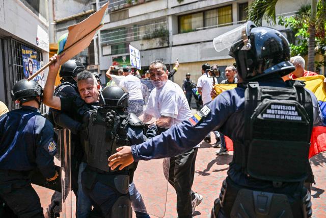 Opponents to the government of Venezuelan interim President Delcy Rodriguez clash with the police as they demonstrate in demand of salary and pension raises in Caracas on April 9, 2026. (Photo by Juan BARRETO / AFP)