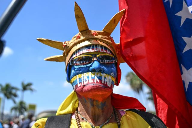 An opponent to the government of Venezuelan interim President Delcy Rodriguez, fancy dressed as the Statue of Liberty, demonstrates in demand of salary and pensions raises in Caracas on April 9, 2026. (Photo by Juan BARRETO / AFP)