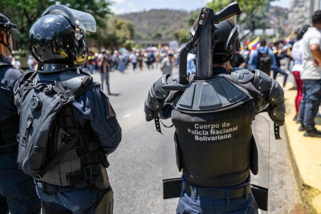 Police are deployed as opponents to the government of Venezuelan interim President Delcy Rodriguez demonstrate in demand of salary and pension raises in Caracas on April 9, 2026. (Photo by Juan BARRETO / AFP)