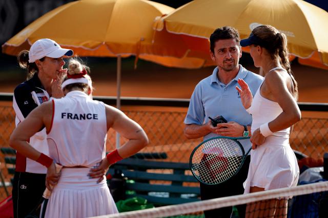 France's team captain Alize Cornet talks with the ITF referee during the match between France's Kristina Mladenovic, and Leolia Jeanjean, against Romania’s Ilinca Dalina Amariei and Carmen Andreea Herea during the Billie Jean King Cup  play-off women's doubles between France and Romania, at Oeiras on the outskirts of Lisbon, on April 9, 2026. (Photo by FILIPE AMORIM / AFP)