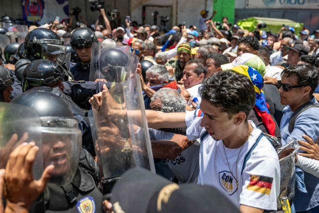 Opponents to the government of Venezuelan interim President Delcy Rodriguez confront the police as they demonstrate in demand of salary and pension raises in Caracas on April 9, 2026. (Photo by Juan BARRETO / AFP)