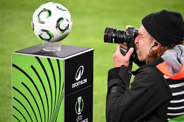 A photographer takes photos of the official matchball ahead of the UEFA Europa Conference League quarter-final first leg football match between 1 FSV Mainz 05 and RC Strasbourg Alsace in Mainz, western Germany on April 9, 2026. (Photo by Kirill KUDRYAVTSEV / AFP)