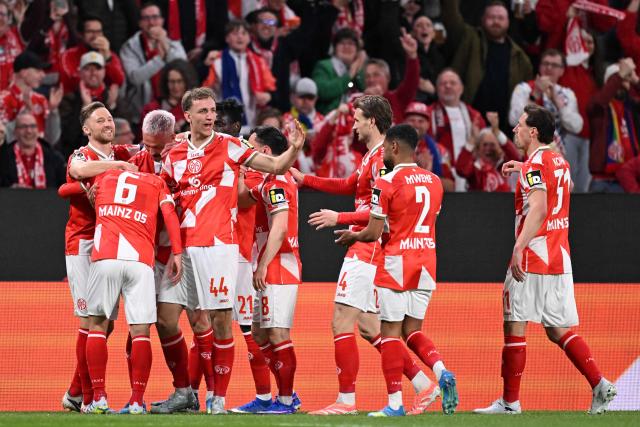 Mainz' Japanese midfielder #06 Kaishu Sano (2L) is celebrated by teammates after scoring his team's first goal with Mainz' Japanese midfielder #24 Sota Kawasaki during the UEFA Europa Conference League quarter-final first leg football match between 1 FSV Mainz 05 and RC Strasbourg Alsace in Mainz, western Germany on April 9, 2026. (Photo by Kirill KUDRYAVTSEV / AFP)