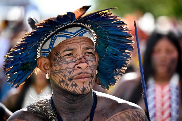 A Brazilian Indigenous man takes part in a protest march as part of the indigenous gathering Acampamento Terra Livre (Free Land Camp) in Brasilia, Brazil, on April 9, 2026. Around 7,000 indigenous people from several ethnic groups take part in the week-long protest to demand land rights, justice, and equal treatment. (Photo by Evaristo Sa / AFP)