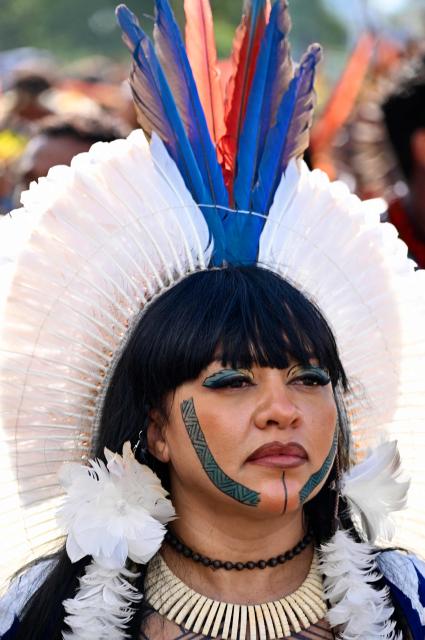 A Brazilian Indigenous woman takes part in a protest march as part of the indigenous gathering Acampamento Terra Livre (Free Land Camp) in Brasilia, Brazil, on April 9, 2026. Around 7,000 indigenous people from several ethnic groups take part in the week-long protest to demand land rights, justice, and equal treatment. (Photo by Evaristo Sa / AFP)