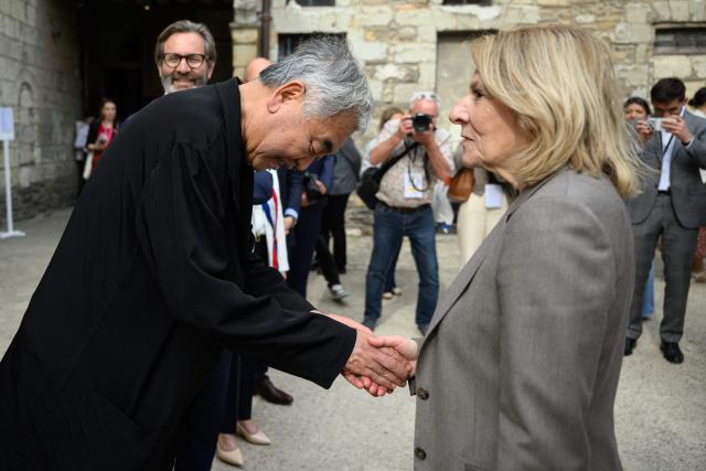 Franc's Culture minister Catherine Pegard shakes hands with Japanese architect Kengo Kuma before the inauguration of the gallery he designed to protect the gate of the Saint-Maurice cathedral in Angers, western France, on April 9, 2026. (Photo by Loic VENANCE / AFP)