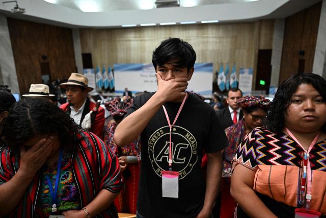 Attendees stand up and turn their backs in protest during a meeting of Guatemala's attorney general Consuelo Porras with the commission that nominates finalists for the election of the attorney general for the next four-year term at the Supreme Court in Guatemala City on April 9, 2026. (Photo by JOHAN ORDONEZ / AFP)
