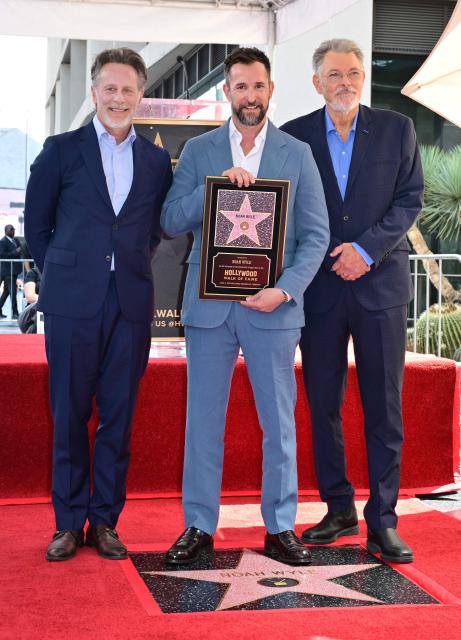 US actor Noah Wyle stands on his star between actor Steven Weber (L) and actor/director Jonathan Frakes (R) during his Walk of Fame star ceremony in Hollywood, California on April 9, 2026. (Photo by Frederic J. BROWN / AFP)