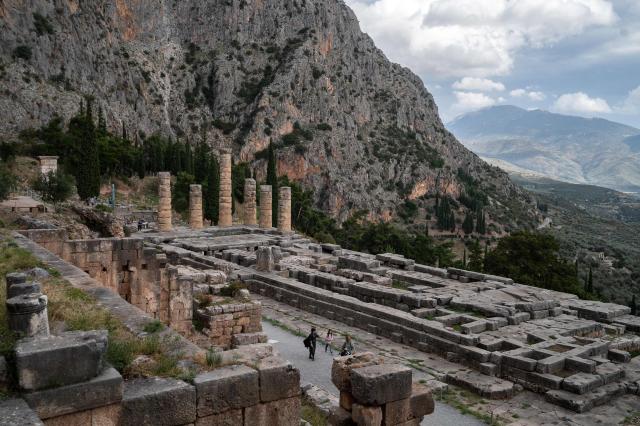 (FILES) Pedestrians visit the archaeological site of Delphi, a UNESCO World Heritage site, in Delphi, on November 17, 2022, amid a conference marking the 50th anniversary of the UNESCO World Heritage Convention. From 2022 to 2025, scientists at the National University of Athens and the National Hellenic Research Foundation examined past and present climate and geological conditions at the 19 sites, looking at prior damage to help determine future vulnerability to extreme events. The sites under scrutiny include Olympia, habitually threatened by forest fires, the ancient theatre of Delphi, where rockslides are a concern. (Photo by Angelos Tzortzinis / AFP)