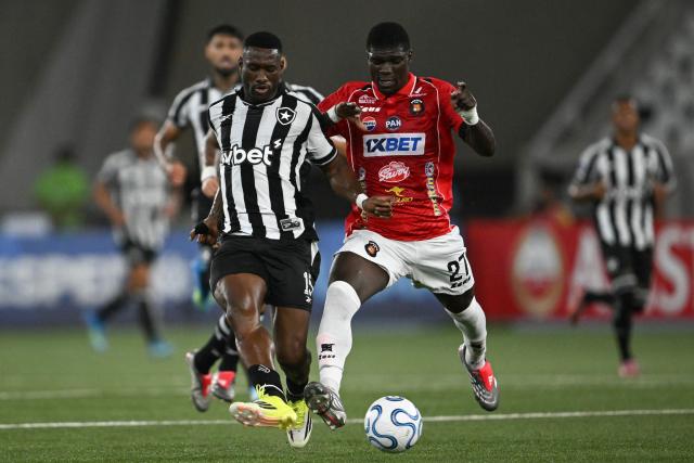 Botafogo's Angolan defender #15 Bastos and Caracas' Colombian forward #27 Sebastian Gonzalez fight for the ball during the Copa Sudamericana group stage football match between Brazil's Botafogo and Venezuela's Caracas FC at the Nilton Santos stadium in Rio de Janeiro, Brazil, on April 9, 2026. (Photo by Mauro PIMENTEL / AFP)
