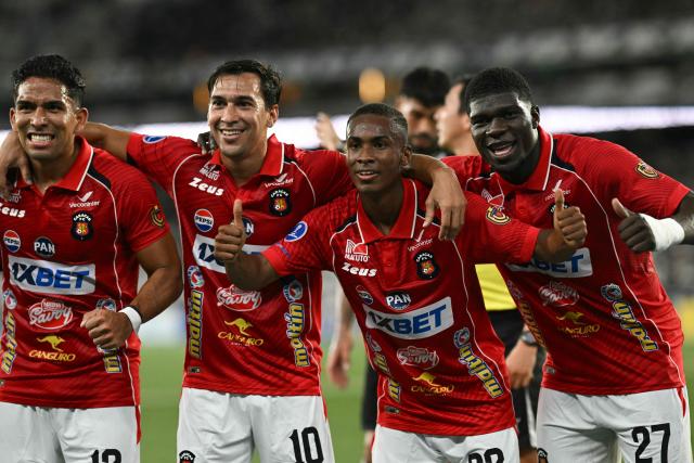 Caracas' midfielder #33 Wilfred Correa (2nd R) celebrates with teammates after scoring the team's first goal during the Copa Sudamericana group stage football match between Brazil's Botafogo and Venezuela's Caracas FC at the Nilton Santos stadium in Rio de Janeiro, Brazil, on April 9, 2026. (Photo by Mauro PIMENTEL / AFP)