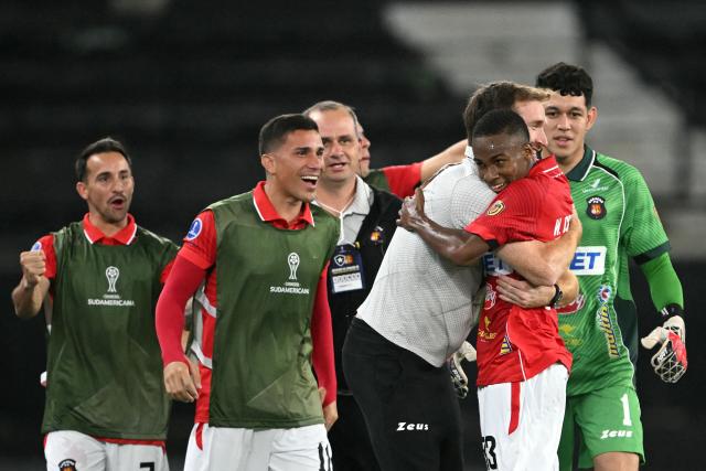 Caracas' midfielder #33 Wilfred Correa celebrates with Caracas' head coach Fernando Aristeguieta after scoring the team's first goal during the Copa Sudamericana group stage football match between Brazil's Botafogo and Venezuela's Caracas FC at the Nilton Santos stadium in Rio de Janeiro, Brazil, on April 9, 2026. (Photo by Mauro PIMENTEL / AFP)