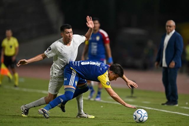 Libertad's midfielder #26 Hernesto Caballero and Universidad Central's Argentine midfielder #06 Francisco Sole fight for the ball during the Copa Libertadores group stage football match between Venezuela's Universidad Central and Paraguay's Libertad at the Olimpico de la UCV stadium in Caracas, on April 9, 2026. (Photo by Juan BARRETO / AFP)