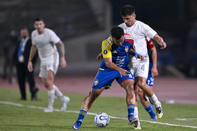 Universidad Central's forward #10 Samuel Sosa and Libertad's defender #04 Nestor Gimenez fight for the ball during the Copa Libertadores group stage football match between Venezuela's Universidad Central and Paraguay's Libertad at the Olimpico de la UCV stadium in Caracas, on April 9, 2026. (Photo by Juan BARRETO / AFP)