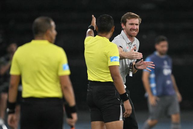 Peruvian referee Kevin Ortega speaks with Caracas' head coach Fernando Aristeguieta during the Copa Sudamericana group stage football match between Brazil's Botafogo and Venezuela's Caracas FC at the Nilton Santos stadium in Rio de Janeiro, Brazil, on April 9, 2026. (Photo by MAURO PIMENTEL / AFP)